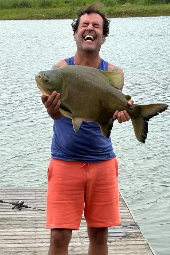 Pescador segurando um grande tambaqui